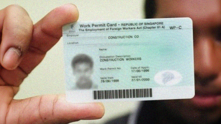 A man holding a Singaporean work permit car symbolizing the S pass.